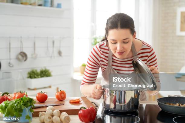 Healthy food at home. Happy woman is preparing the proper meal in the kitchen.